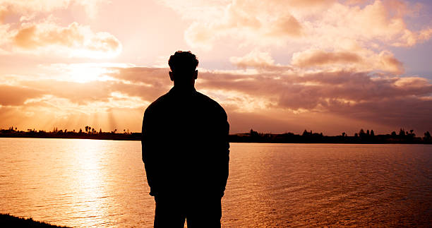 Person looking toward a city skyline at sunset